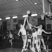 grupa mężczyzn w strojach sportowych skacząca do piłki do koszykówki z dużą liczbą osób na trybunach w tle