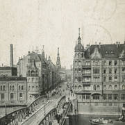 most nad rzeką, w głębi ulica zabudowana kamienicami