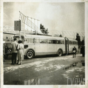 kilkoro osób przyglądających się samochodowi stojącemu na placu targowym 