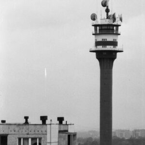wysoka budowla na tle budynków mieszkalnych