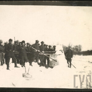 Grupa mężczyzn w różnym wieku, w mundurach wojskowych, trzymająca narzędzia do rozbijania śniegu i lodu.