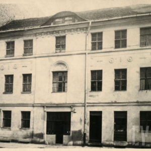 elewacja frontowa dwupiętrowej kamienicy z rzędami okien i zdobieniami sztukatorskimi nad oknami pierwszego piętra