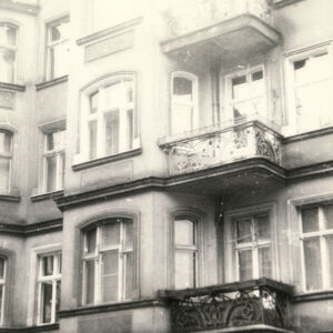 rzędy okien i kute balkony frontowej elewacji kamienicy