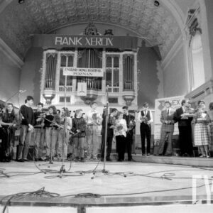 grupa młodych ludzi trzymająca w rękach bukiety kwiatów na tle organów