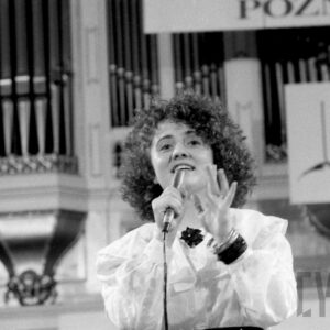 młoda kobiety śpiewająca do mikrofonu na tle organów