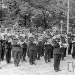 grupa mężczyzn w różnym w wieku ubrana w mundury górnicze, grająca na różnych instrumentach muzycznych