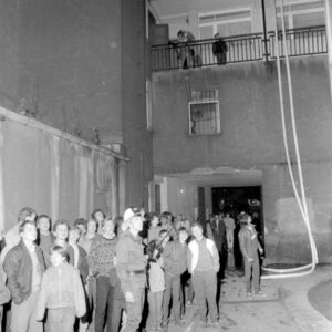 strażak i grupa gapiów przyglądająca się akcji gaśniczej