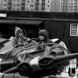 dzieci na karuzeli na tle bloków mieszklanych