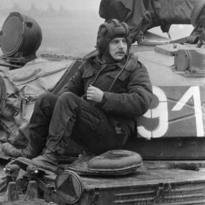 żołnierz siedzący na czołgu na poligonie