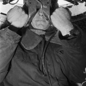 żołnierz patrzący w wizjer (peryskop?) wewnątrz czołgu na poligonie