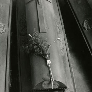 drewniana trumna z krzyżem i wiązanką kwiatów na wieku