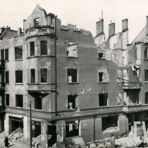 kilkupiętrowy wypalony budynek, pozbawiony dachu i okien, z częściowo zburzoną jedną ścianą