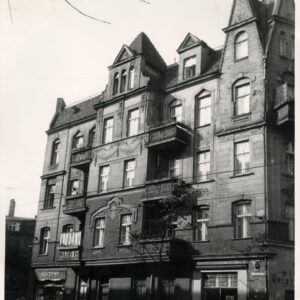 czteropiętrowa kamienica narożnym szczytem, ozdobionym wieżyczką