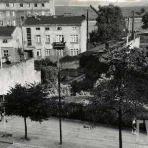 na pierwszym planie chodnik, w głębi kilkupiętrowe kamienice