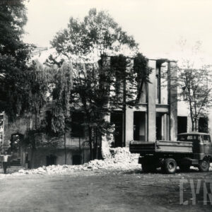 budynek w trakcie rozbiórki, przed budynkiem gruz i zaparkowana ciężarówka