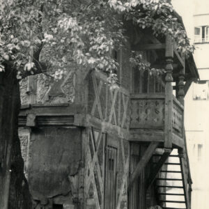 dwukondygnacyjny dom o konstrukcji szkieletowej, drewnianej z drewnianymi schodami prowadzącymi na pierwsze piętro