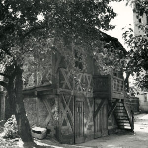 dwukondygnacyjny dom o konstrukcji szkieletowej, drewnianej z drewnianymi schodami prowadzącymi na pierwsze piętro