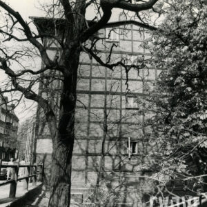 boczna ściana budynku o konstrukcji szkieletowej, drewnianej, wypełnionej cegłami, przed domem drzewo