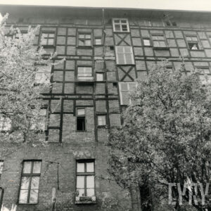 trzypiętrowy budynek o konstrukcji szkieletowej, drewnianej, wypełnionej cegłami