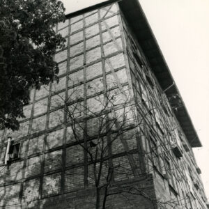 trzypiętrowy budynek o konstrukcji szkieletowej, drewnianej, wypełnionej cegłami