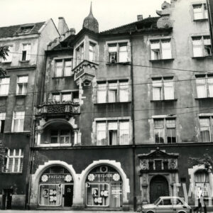 czterokondygnacyjna kamienica z poddaszem i zdobionym szczytem z wieżyczkami