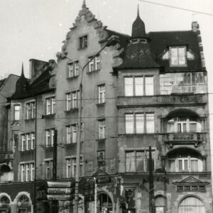 czterokondygnacyjna kamienica z poddaszem i zdobionym szczytem z wieżyczkami