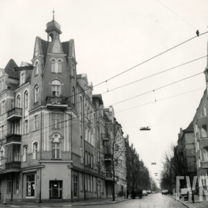 czteropiętrowa kamienica narożnym szczytem, ozdobionym wieżyczką, z prawej wlot ulicy