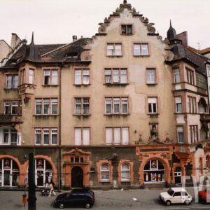 czterokondygnacyjna kamienica z poddaszem i zdobionym szczytem z wieżyczkami