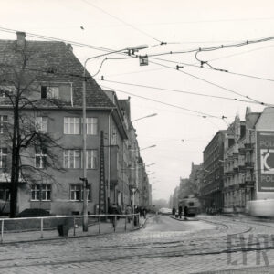 brukowana ulica z torami tramwajowymi, po obu stronach ulicy kilkupiętrowe kamienice