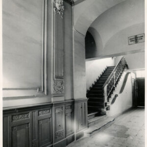 bogato zdobiona ściana, w głębi schody z drewnianą balustradą