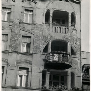 fragment ściany z oknami i loggiami ze zdobionymi balustradami, częściowo odpadający tynk