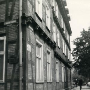 fragment narożnika domu drewniano-ceglanego z użytkowym poddaszem, z prawej, w oddali drzewo