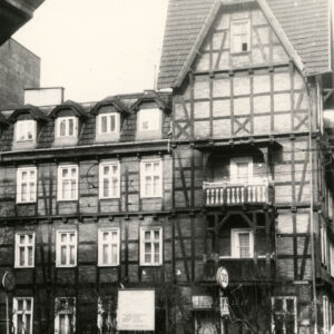 dwupiętrowy dom drewniano-ceglany z użytkowym poddaszem, narożnik z dodatkową kondygnacją, nakrytą stromym dwuspadowym dachem