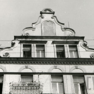 ozdobny szczyt kamienicy z oknami