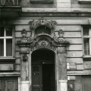 drewniane drzwi nad nimi bogata dekoracja rzeźbiarska