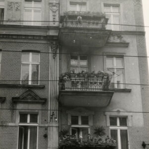 fragment ściany frontowej kamienicy z oknami i balkonami