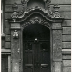 drewniane drzwi nad nimi bogata dekoracja rzeźbiarska