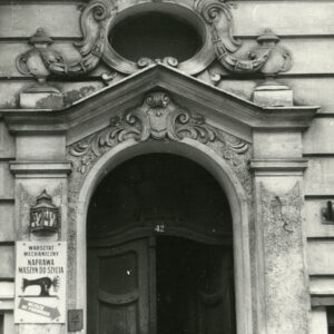 drewniane drzwi nad nimi bogata dekoracja rzeźbiarska