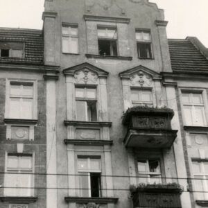 fragment elewacji kamienicy z mieszkalnym poddaszem zakończony zdobionym szczytem