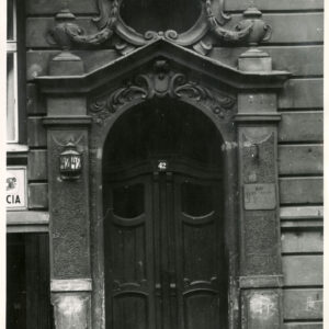 drewniane drzwi nad nimi bogata dekoracja rzeźbiarska