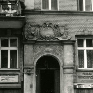 drewniane drzwi nad nimi bogata dekoracja rzeźbiarska