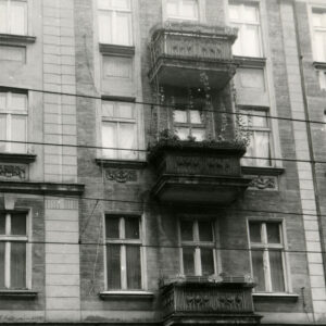 fragment ściany frontowej kamienicy z oknami i balkonami