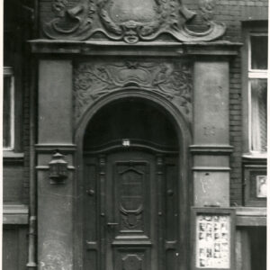 drewniane drzwi nad nimi bogata dekoracja rzeźbiarska