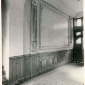 zdobiona ściana pilastrami, w głębi, z prawej fragment drewnianych drzwi wejściowych, zdobiona posadzka