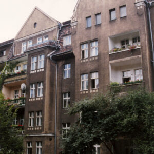 czteropiętrowa kamienica z użytkowym poddaszem, przed budynkiem drzewa