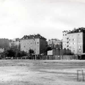 z przodu pusta przestrzeń, w głębi kilkupiętrowe kamienice