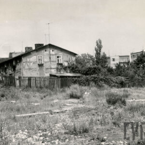 jednopiętrowy dom z poddaszem, otoczony drewnianym płotem