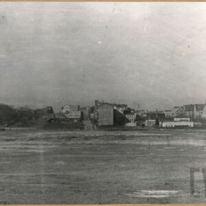 na pierwszym planie pusta przestrzeń, daleko, w głębi zabudowania