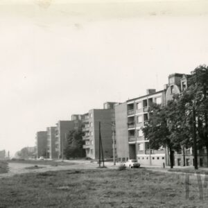 na pierwszym planie pusta przestrzeń, dalej kilkupiętrowe domy mieszkalne