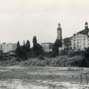 na pierwszym planie nieużytki, w głębi z prawej budynek seminarium i kościoła z wysokim budynkiem z krzyżem (dzwonnicą), z lewej wielopiętrowy budynek